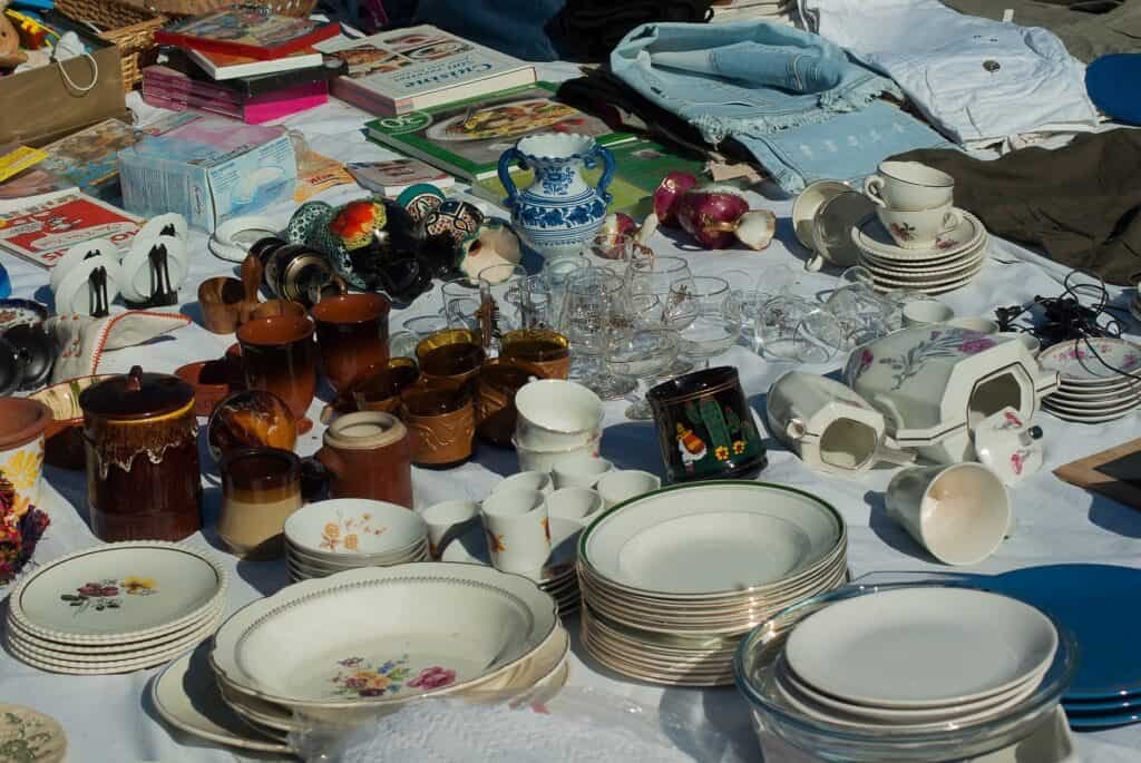 A table covered in stuff at a yard sale.