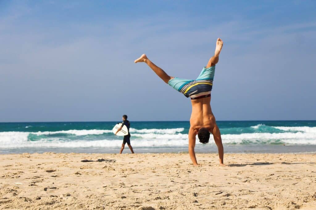 Man doing a cartwheel on a beach.