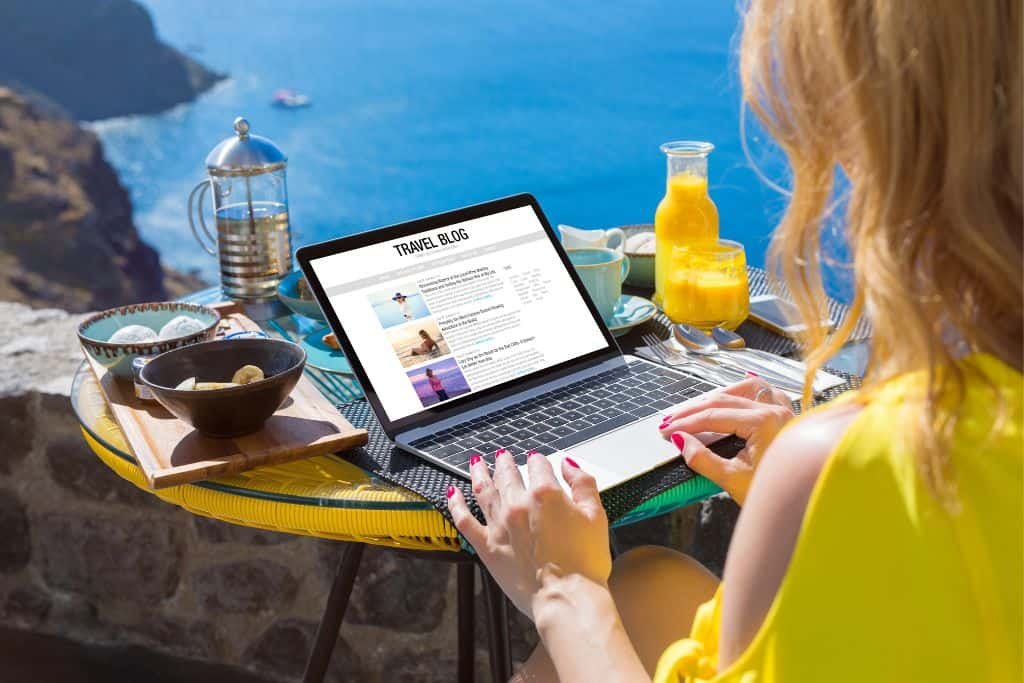Woman with a laptop open to a digital nomad blog