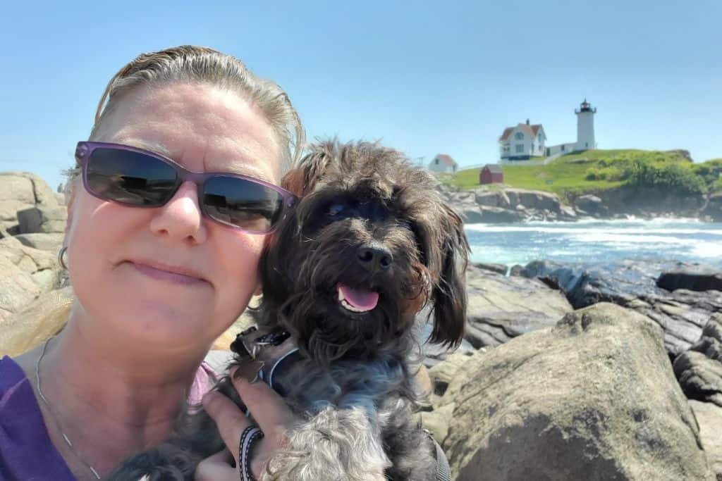 Sherry and Shelby at the coast with a lighthouse in the background.