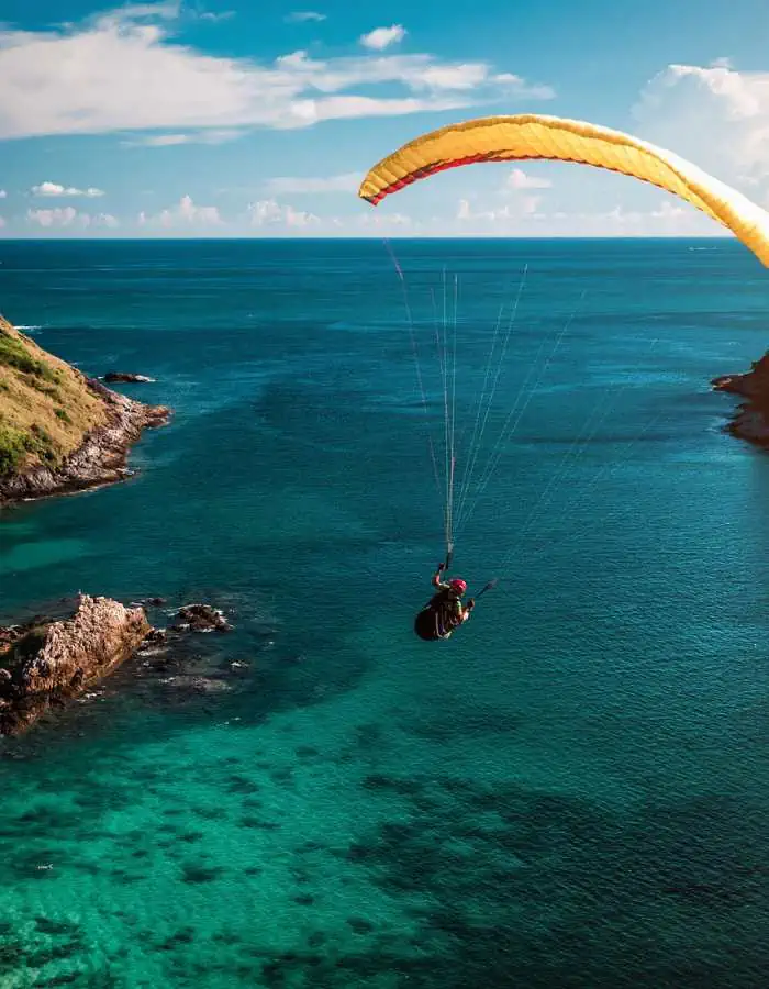 Skydivers over a beautiful turquoise ocean