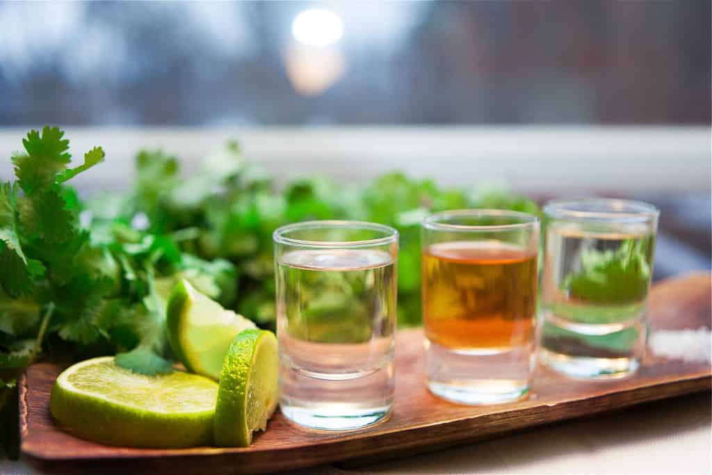 Shots of tequila with lime wedges