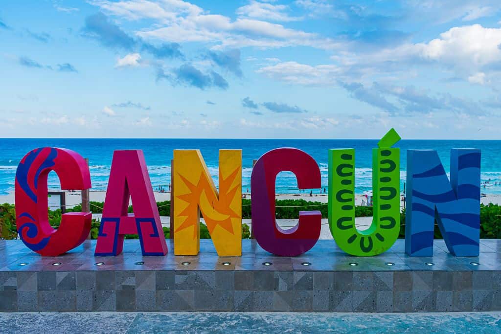 Colorful Cancun sign in front of the ocean.