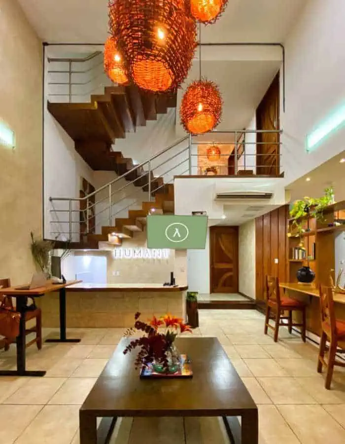 large room with a spiral staircase and orange hanging lights. It's a beautiful spot for coliving in Mexico.