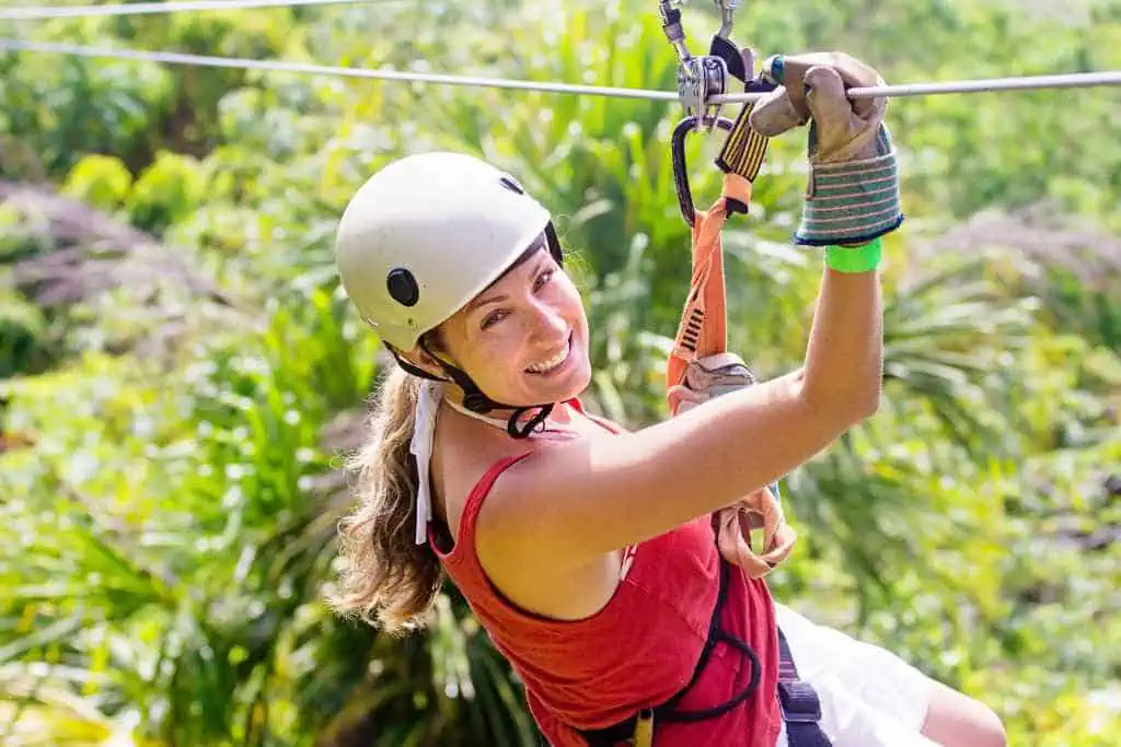 Woman ziplining with a big smile.
