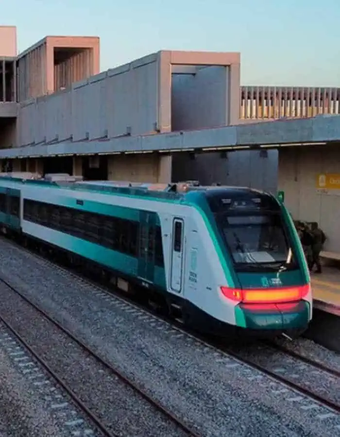 Modern 'Tren Maya' train at dusk, with its sleek design and distinctive teal and white colors, ready to embark on a scenic journey from Cancun.