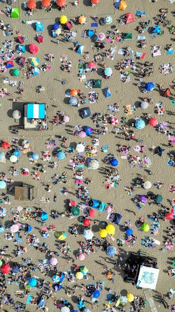 Vibrant aerial shot of a crowded beach with umbrellas and people.